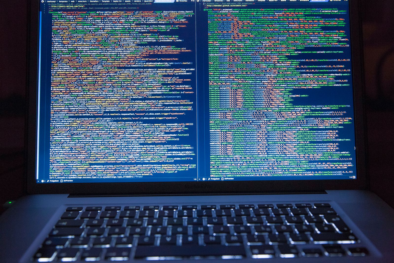 Laptop con código fuente en doble pantalla