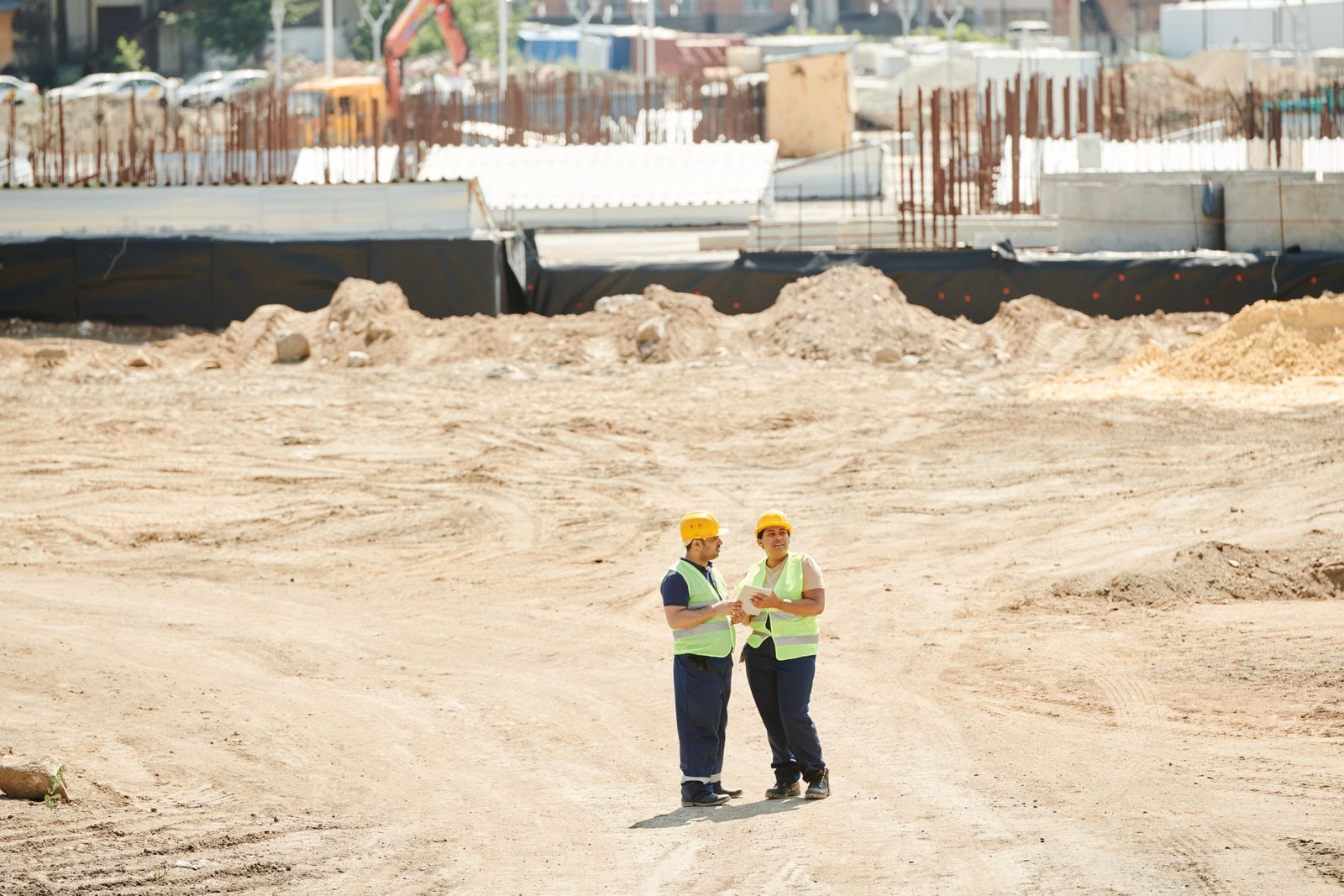 Ingenieros supervisando una obra con planos en el sitio